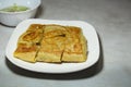 Chicken Murtabak is placed in a white plate. Chicken Murtabak is a very delicious Muslim food