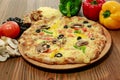 Chicken and mushroom pie pizza with bell pepper, black olive, tomato and cheese served in wooden board isolated on table side view Royalty Free Stock Photo