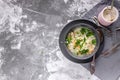 Chicken noodle soup with herbs and cheese sauce on a gray concrete background. Horizontal shot. Top view. Copy space Royalty Free Stock Photo