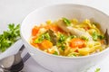 Chicken noodle soup and vegetables in a white bowl on a white ba Royalty Free Stock Photo