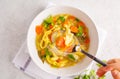 Chicken noodle soup and vegetables in a white bowl on a white ba Royalty Free Stock Photo