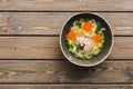 Chicken noodle soup on a wooden plank table. Top view, copy space