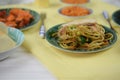 Chicken noodles served on a table with traditional Chinese dishes