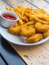 Chicken nuggets with french fries, ketchup on wooden background Royalty Free Stock Photo