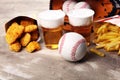 Chicken nuggets and french fries on the table with draft beer. Baseball party food with balls for the playoffs