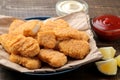 chicken nuggets with red and white sauce on a brown wooden background. fast food close-up Royalty Free Stock Photo