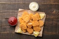 chicken nuggets with red and white sauce on a brown wooden background. view from above Royalty Free Stock Photo