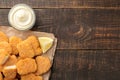 chicken nuggets with white sauce on a brown wooden background. fast food view from above Royalty Free Stock Photo