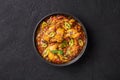 A Chicken Patiala in black bowl on dark slate table top. Murg Patiala is indian cuisine curry dish. Asian food and meal Royalty Free Stock Photo