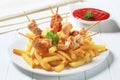 Chicken pieces on sticks and French fries Royalty Free Stock Photo