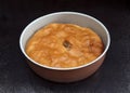 Chicken and potato pie in casserole against black marble background