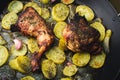 Baked chicken with potatoes, onion and garlic on wooden table