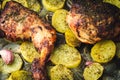 Baked chicken with potatoes, onion and garlic on wooden table