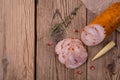 Chicken roll with paprika lies on an old wooden table with a sprig of thyme, mini corn and pomegranate seeds. farm style