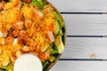 Chicken salad with grated cheddar topping and ranch dressing close up in a bowl on wooden background with copy space Royalty Free Stock Photo