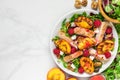 Chicken salad with grilled peach, mixed salad, feta cheese, raspberries and walnuts in a plate. healthy food. top view Royalty Free Stock Photo