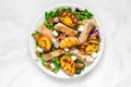 Chicken salad with grilled peach, mixed salad, feta cheese and walnuts in a plate. healthy food Royalty Free Stock Photo