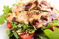 A chicken salad with rucola bacon and tomato