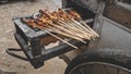 Chicken satay being grilled on a traditional grill on a cart. Sate is a typical dish of Madura, Indonesia