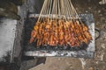 Chicken satay being grilled on a traditional grill on a cart. Sate is a typical dish of Madura, Indonesia