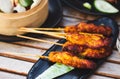 Chicken satay pieces on wooden skewers on a plate Royalty Free Stock Photo