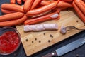 Chicken sausages on a cutting board. A piece of sausage on a fork