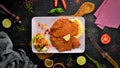 Chicken schnitzel with mashed potatoes on a plate. On a wooden background.