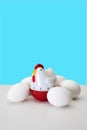 Chicken Shaped Kitchen Timer with Eggs on a White Table and Vibrant Blue Background Royalty Free Stock Photo