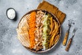 Chicken Shawarma Doner kebab on a plate with french fries, vegetables and salad. Gray background. Top view Royalty Free Stock Photo