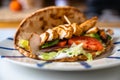 Chicken shawarma in pita bread with vegetable salad on plate on table Royalty Free Stock Photo