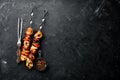 Chicken shish kebab with onions and tomatoes. Barbecue. On a black background. Top view. Free space for your text. Royalty Free Stock Photo