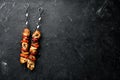 Chicken shish kebab with onions and tomatoes. Barbecue. On a black background. Top view. Royalty Free Stock Photo