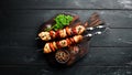 Chicken shish kebab with onions and tomatoes. Barbecue. On a black background. Top view. Royalty Free Stock Photo