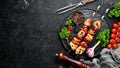 Chicken shish kebab with onions and tomatoes. Barbecue. On a black background. Top view. Free space for your text. Royalty Free Stock Photo