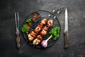 Chicken shish kebab with onions and tomatoes. Barbecue. On a black background. Top view. Free space for your text. Royalty Free Stock Photo