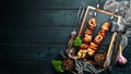 Chicken shish kebab with onions and tomatoes. Barbecue. On a black background. Top view. Free space for your text. Royalty Free Stock Photo