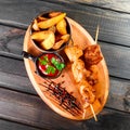 Chicken skewers with sauce and potatoes fries in a bucket Royalty Free Stock Photo