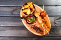 Chicken skewers with sauce and potatoes fries in a bucket on wooden cutting board. Royalty Free Stock Photo