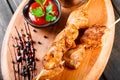 Chicken skewers with sauce and potatoes fries in a bucket on wooden cutting board Royalty Free Stock Photo