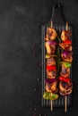 Chicken skewers with slices of sweet peppers and onion. Shish kebab grilled meat on black background. top view Royalty Free Stock Photo