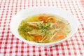 Chicken soup or broth with noodels, chicken meat pieces , carrot slices and herbs Royalty Free Stock Photo