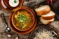 Chicken soup or broth with noodles, herbs and vegetables in bowl with sour cream, bread, pepper on a wooden rustic background. Top Royalty Free Stock Photo