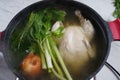 Chicken soup, chicken broth, with whole chicken and vegetables in a pot. Royalty Free Stock Photo