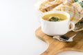 Healthy chicken soup with dill in a white bowl on a wooden cutting board with metal spoon and yellow kitchen towel Royalty Free Stock Photo