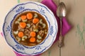 Chicken soup on old vintage table with carrots and selery on top Royalty Free Stock Photo