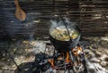 Chicken soup in a pot is cooked on an open fire Royalty Free Stock Photo