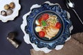 Chicken soup with Udon noodles in a blue ceramic plate. Copy of the space. Vertical photo. Macro photo on a dark background. Top Royalty Free Stock Photo