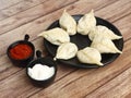 Chicken steam momo. Nepalese Traditional dish Momo stuffed with chicken and then cooked and served with sauce over a rustic wooden