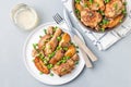 Chicken stew with potatoes, mushrooms and green peas, on white plate and in a metal pot, top view, horizontal