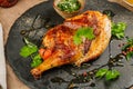 Chicken Tabaka with sauce on stone plate. Royalty Free Stock Photo